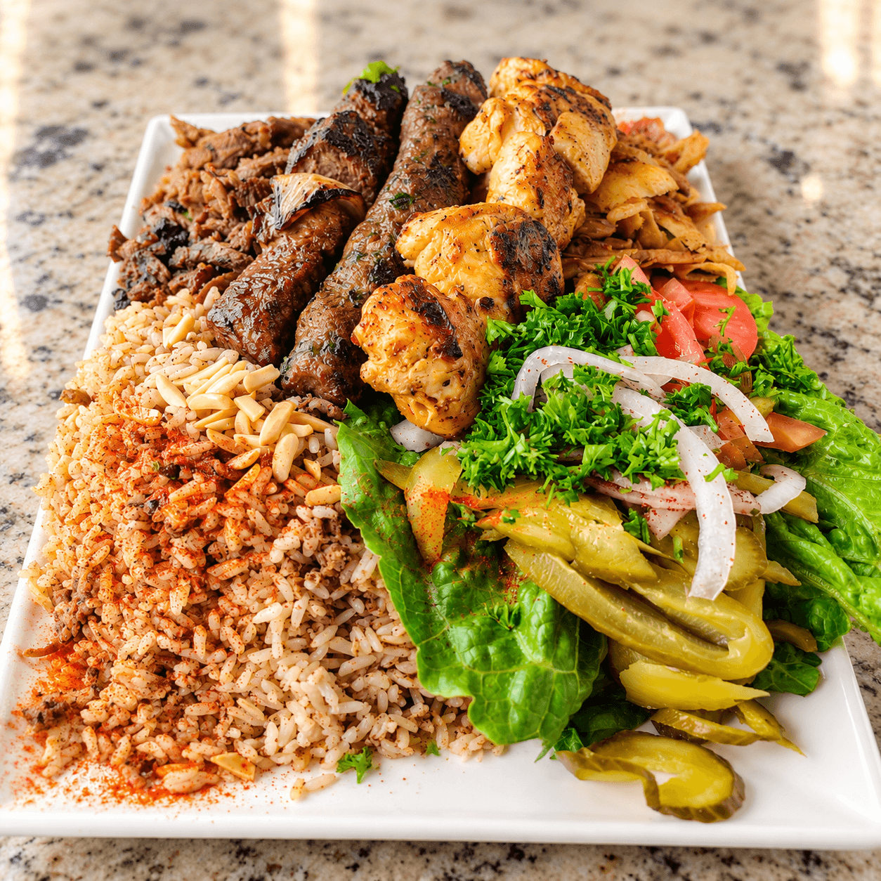 Hamido's special plate with kafta, shish tawook, meat and chicken shawarma, rice, pickles and parsley